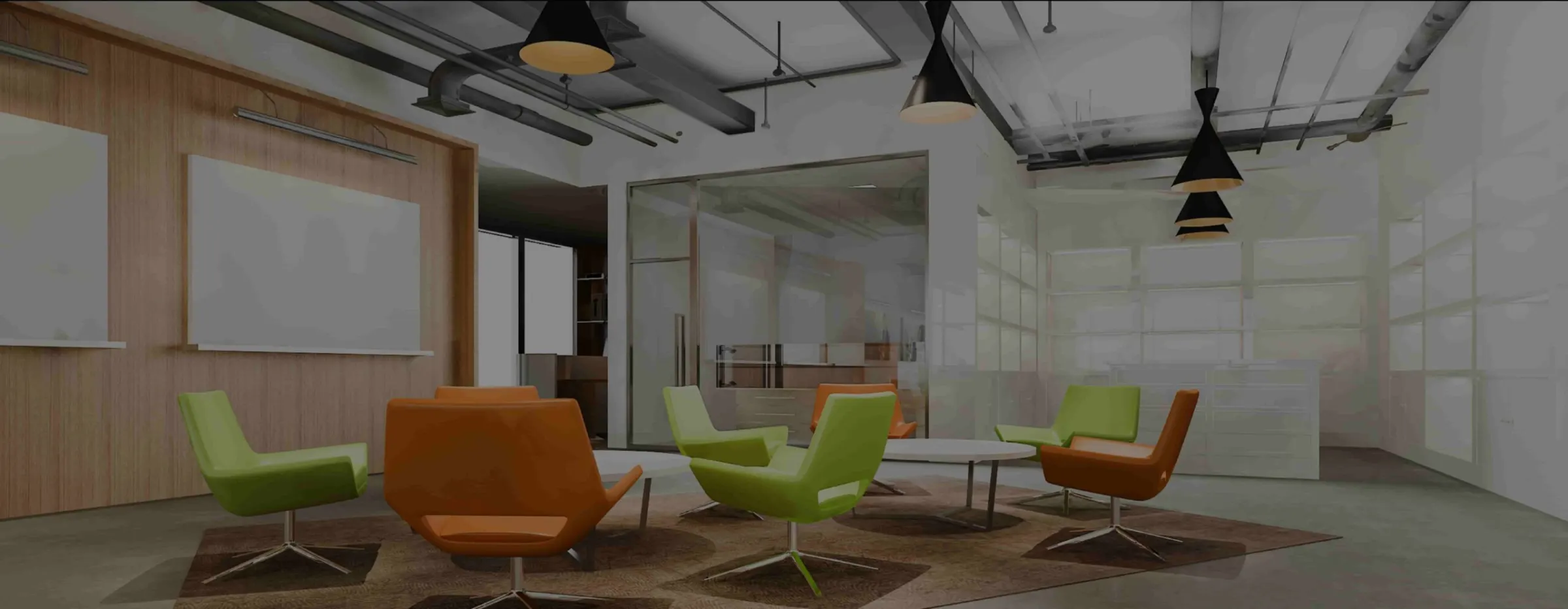 Zona de reunión de oficina con butacas de colores y techo industrial