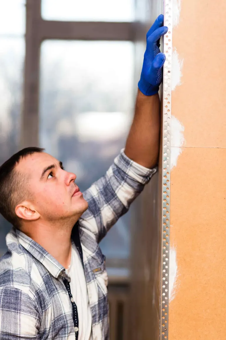Instalador colocando un panel de revestimiento en obra